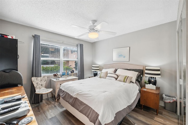 bedroom featuring ceiling fan, a textured ceiling, and wood finished floors