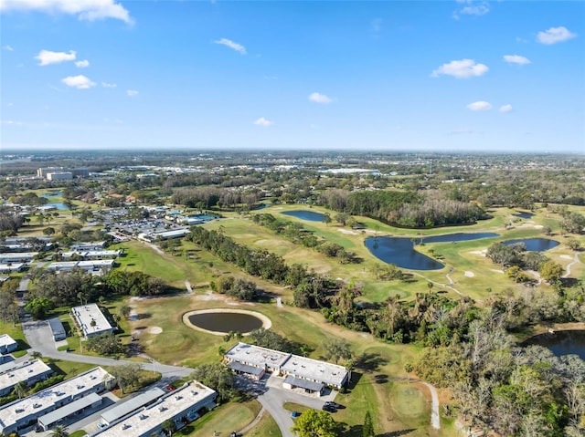 birds eye view of property with view of golf course and a water view