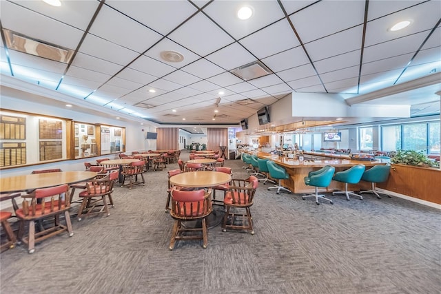 carpeted dining space featuring a drop ceiling