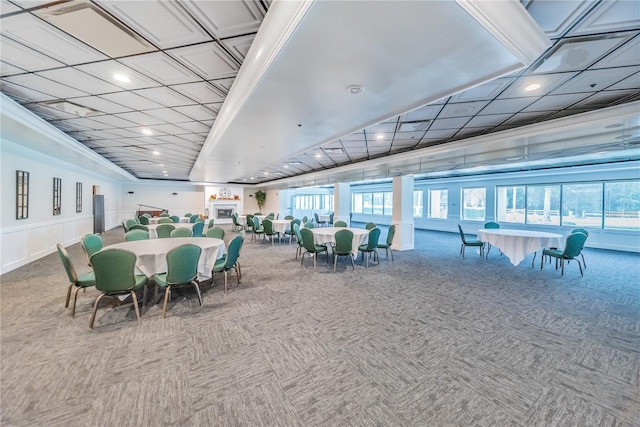 dining space featuring carpet floors, a decorative wall, crown molding, and recessed lighting