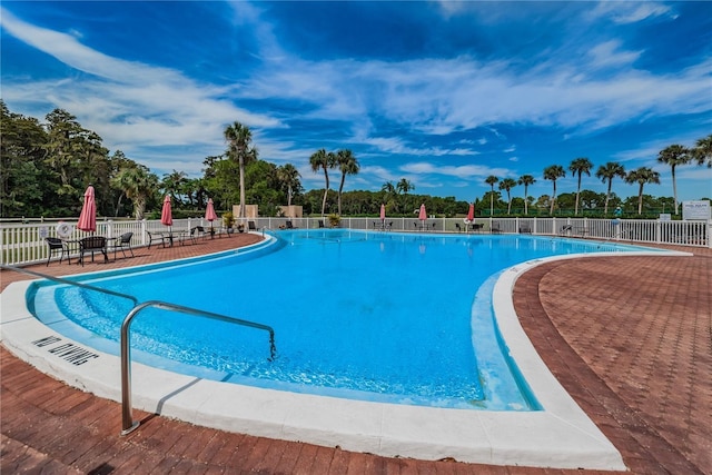 community pool with fence and a patio