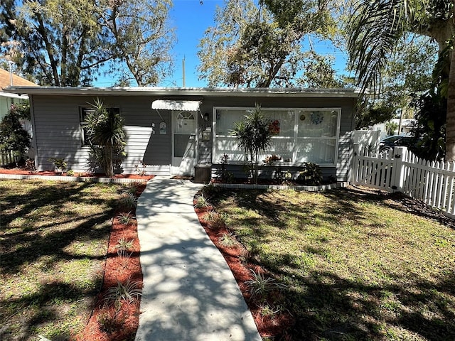 view of front of home with a front lawn and fence