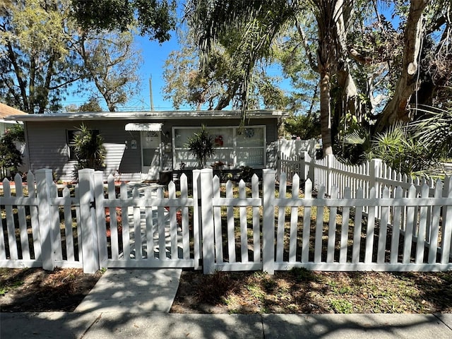 view of front of property featuring a fenced front yard and a gate