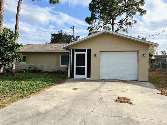 single story home with driveway, brick siding, a garage, and stucco siding