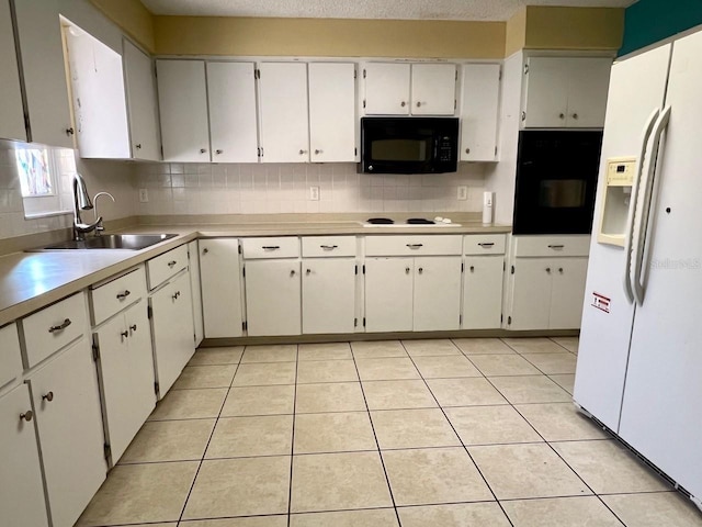 kitchen featuring light tile patterned floors, black appliances, a sink, and decorative backsplash