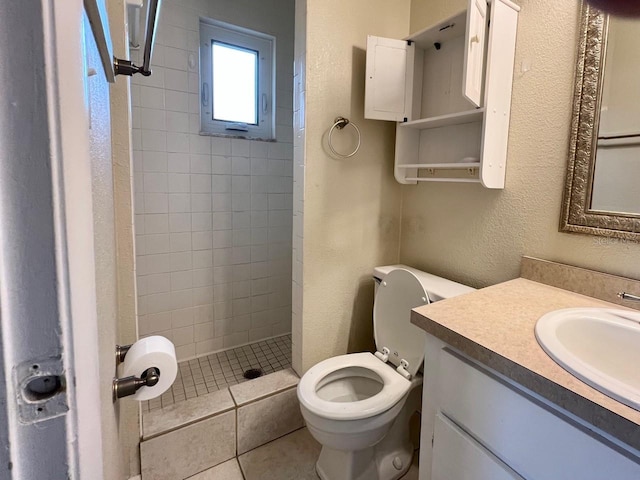 bathroom with a textured wall, toilet, a shower stall, and vanity