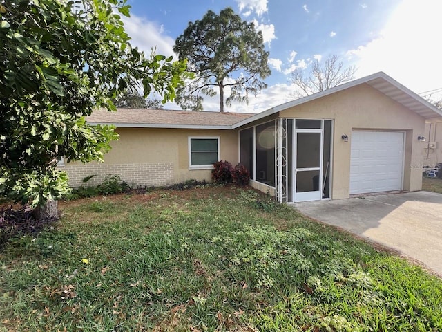 single story home with brick siding, stucco siding, an attached garage, a sunroom, and driveway