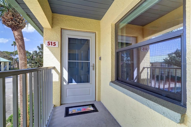 doorway to property featuring stucco siding