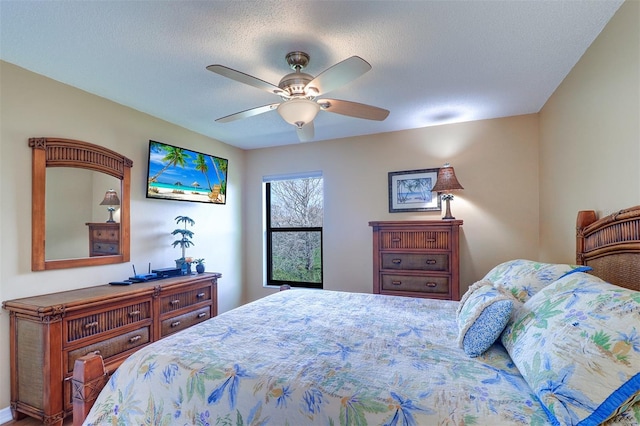 bedroom with a ceiling fan and a textured ceiling