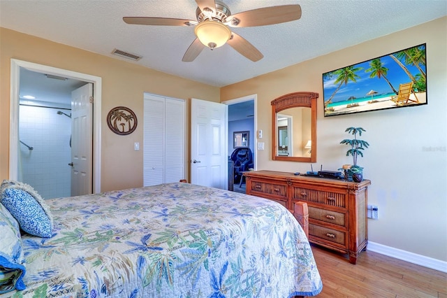 bedroom with light wood-type flooring, baseboards, visible vents, and a textured ceiling