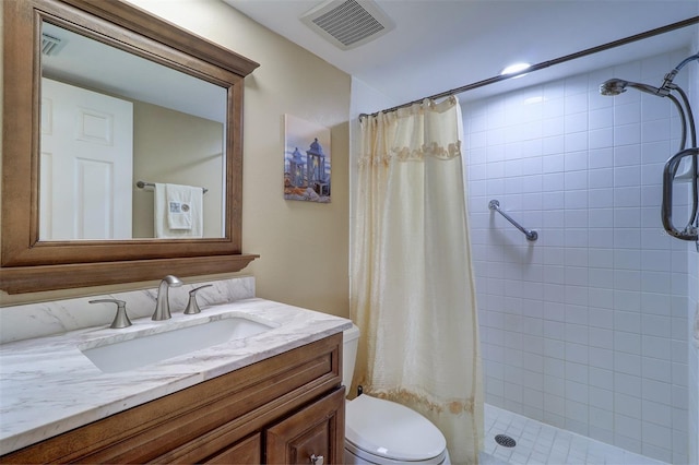 full bathroom featuring visible vents, a tile shower, vanity, and toilet