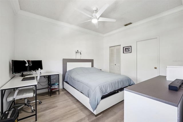 bedroom featuring visible vents, light wood-style floors, ceiling fan, and crown molding