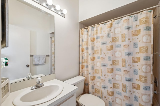 bathroom featuring toilet, vanity, and a shower with curtain