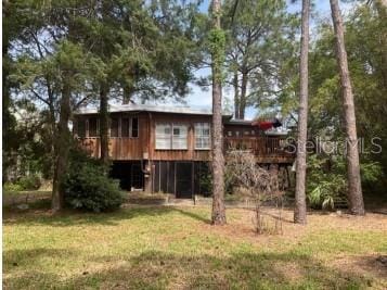 back of property featuring a deck and a yard