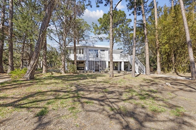 back of house with stairway, board and batten siding, and a wooden deck