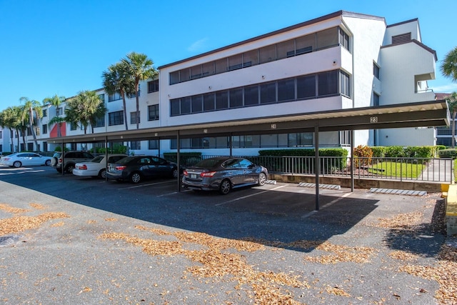 view of property featuring covered parking and fence