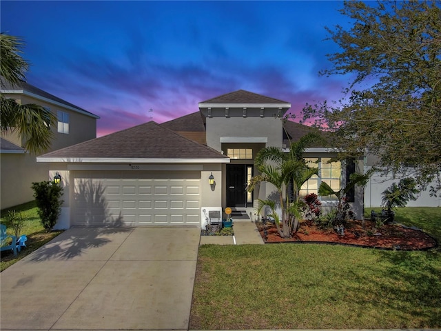 mediterranean / spanish-style home with driveway, roof with shingles, an attached garage, a yard, and stucco siding