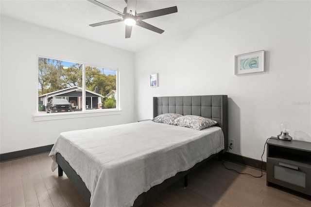 bedroom with a ceiling fan, baseboards, and wood finished floors