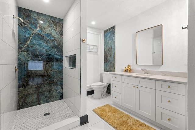 full bath featuring tile patterned flooring, a tile shower, vanity, and toilet