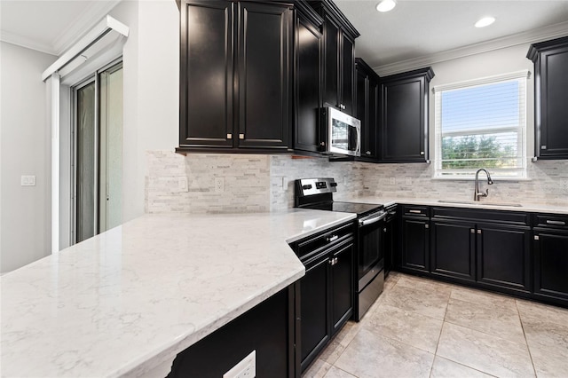 kitchen with stainless steel appliances, dark cabinetry, a sink, and ornamental molding