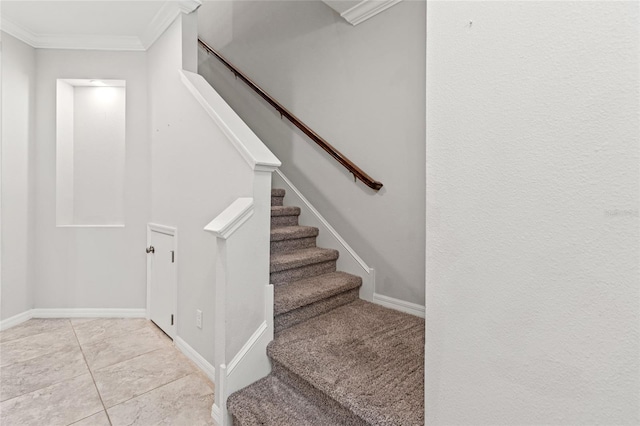 staircase with crown molding, baseboards, and tile patterned floors