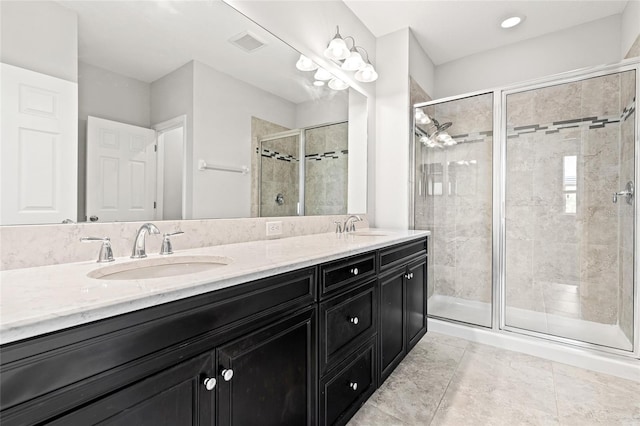 bathroom with double vanity, a sink, visible vents, and a shower stall