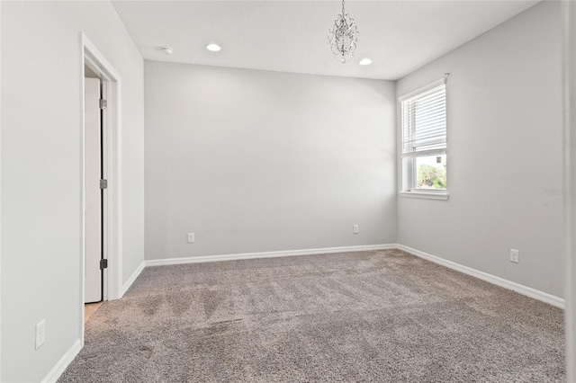 carpeted empty room with a chandelier, recessed lighting, and baseboards