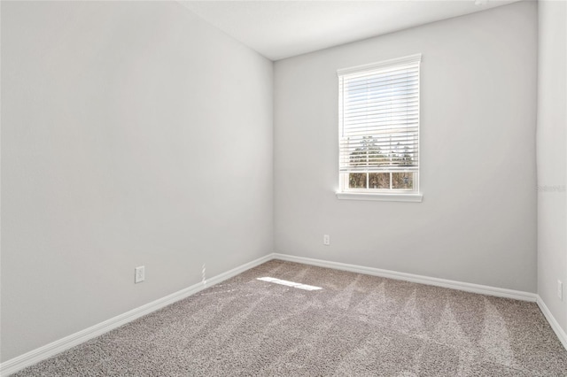 empty room featuring carpet floors and baseboards