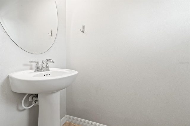 bathroom with baseboards and a sink