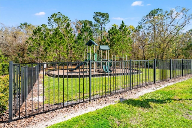 community jungle gym with a lawn and fence