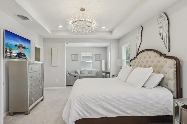 bedroom featuring visible vents, light carpet, a raised ceiling, multiple windows, and a chandelier