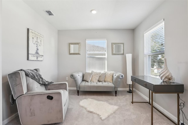 sitting room with baseboards, plenty of natural light, and carpet floors