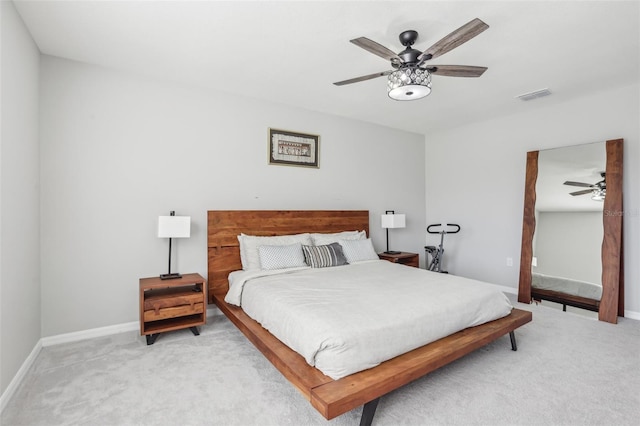 bedroom with a ceiling fan, light colored carpet, visible vents, and baseboards