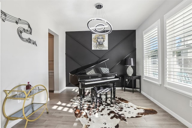 sitting room with baseboards, an inviting chandelier, and wood tiled floor