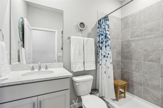 bathroom with vanity, a shower stall, and toilet