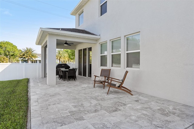 view of patio featuring outdoor dining space, a ceiling fan, and fence