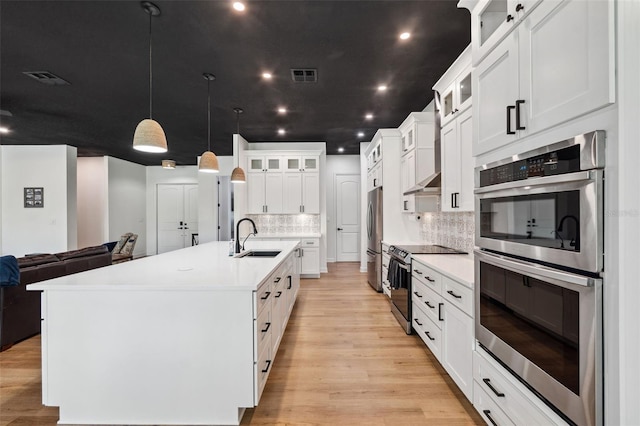 kitchen featuring open floor plan, light countertops, appliances with stainless steel finishes, and a sink