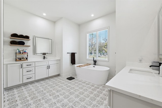 full bath with a soaking tub, two vanities, a sink, and recessed lighting