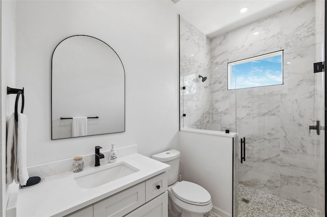 bathroom with a marble finish shower, vanity, and toilet