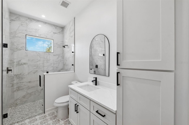 bathroom featuring toilet, recessed lighting, visible vents, vanity, and a marble finish shower