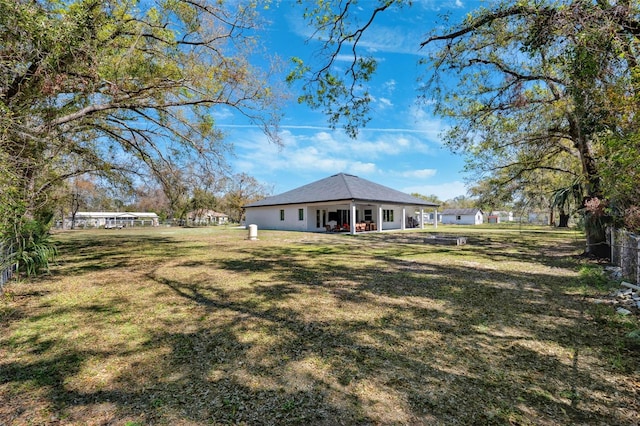 rear view of house featuring a yard