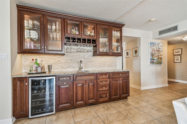 634 Edgewater Dr Unit 744, Dunedin, FL 34698 - indoor wet bar with beverage cooler, a textured ceiling, light tile patterned floors, and decorative backsplash