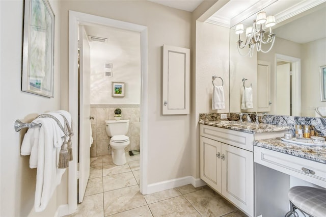634 Edgewater Dr Unit 744, Dunedin, FL 34698 - full bath featuring tile patterned flooring, vanity, a chandelier, tile walls, and wainscoting