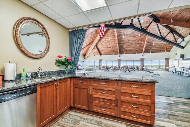 634 Edgewater Dr Unit 744, Dunedin, FL 34698 - kitchen featuring stainless steel dishwasher, light wood-style flooring, dark stone counters, brown cabinetry, and wooden ceiling