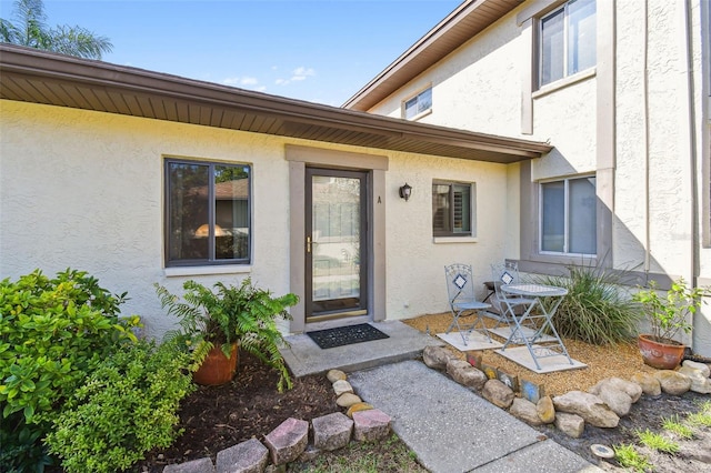 entrance to property featuring stucco siding