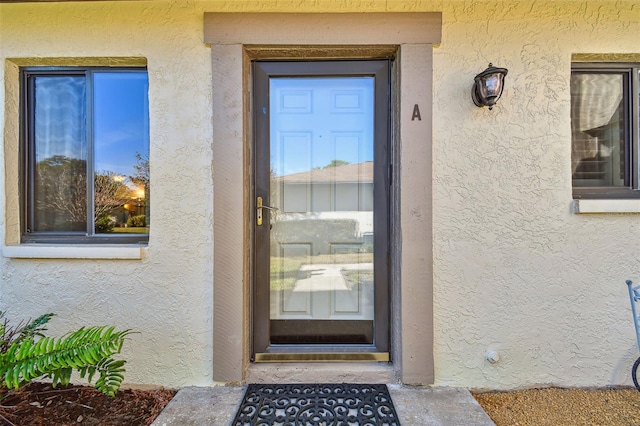 view of exterior entry featuring stucco siding