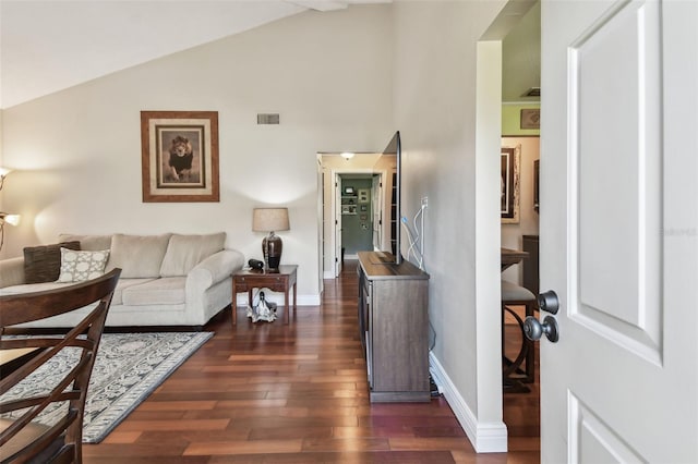 living room featuring lofted ceiling, dark wood-style flooring, visible vents, and baseboards