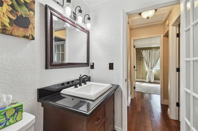 bathroom featuring crown molding, a textured wall, toilet, vanity, and hardwood / wood-style flooring