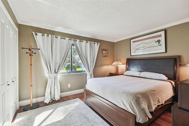 bedroom featuring ornamental molding, a closet, baseboards, and wood finished floors