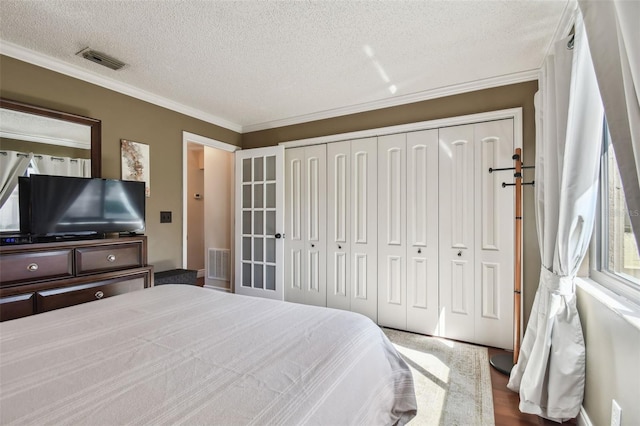 bedroom with visible vents, a closet, and ornamental molding